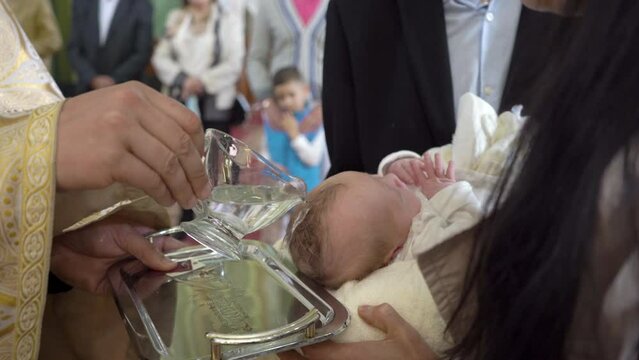 baptism of water baby,religious rite of infant baptism, pour water on the baby's head