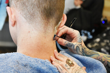 Straight razor being used in barbershop - obrazy, fototapety, plakaty
