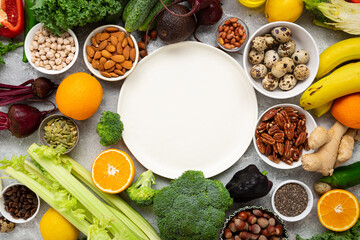 Balanced food background with vegetables and nuts and white plate