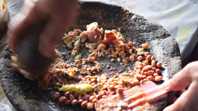 Preparing rujak petis.Rujak petis is traditional food from Java made from steamed mix vegetables, black sauce made from fried garlic, chillies, petis (black fermented shrimp paste) and ground peanuts