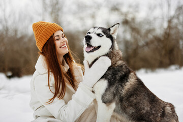 cheerful woman winter clothes walking the dog in the snow fresh air