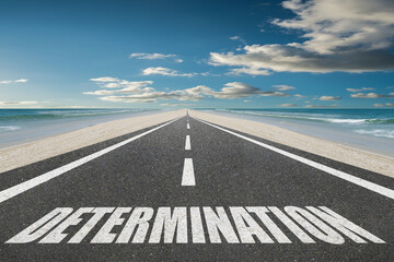 Determination word written on a highway at sunset at the beach for inspirational motivation concept.