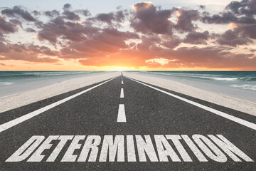 Determination word written on a highway at sunset at the beach for inspirational motivation concept.