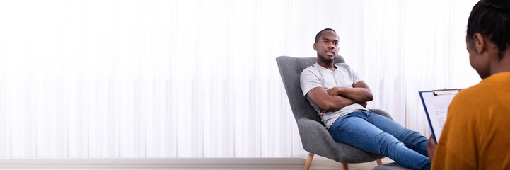 Man Sitting On Chair Near Psychologist