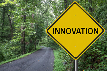 Innovation sign in the woods with road leading to future success.