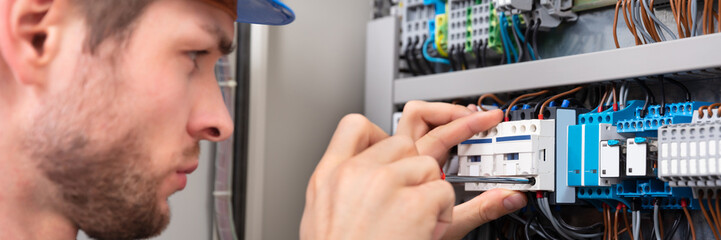 Technician Repairing Fuse Box With Screwdriver