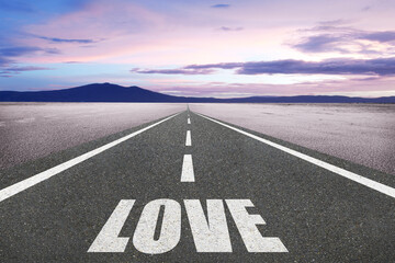The word Love on a beautiful highway leading to infinity.