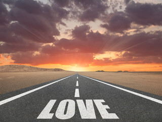 The word Love on a beautiful highway leading to infinity.