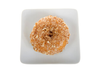 Top view flat lay of one crumb coated cinnamon cake donut on a small square off white porcelain...