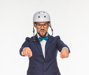 a cheerful guy poses in a white helmet and a blue jacket on a white background isolated in the studio. the guy shows a motorcycle. imitates riding a bike on a motorcycle