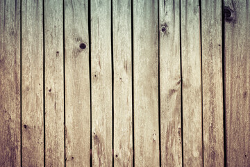 Light brown wooden wall detail of natural planks in faded uneven texture. Closeup of abstract pale wood fence background from old weathered boards with knots or rough cracked surface. Striped pattern.