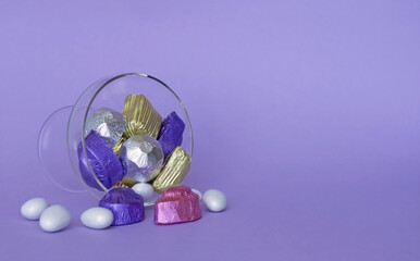 Feast Concept, Traditional Turkish Ramadan sweet sugar candy, and chocolates in glass bowl with purple background.