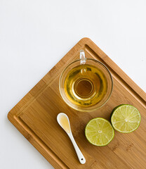 cup of tea, lemons and spoon of honey on a cutting board