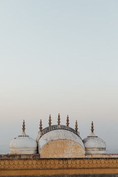 Spires and domes on top of a roof in India