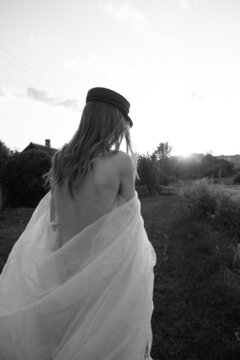 long-haired girl in a beret with a bare back wrapped in lintel fabric