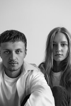 black and white portrait of brother and sister looking right in the studio