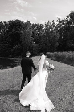 black and white photo of the bride and groom walking on a wedding walk in a beautiful area