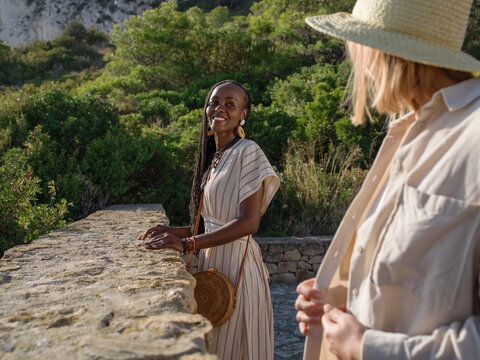 Black tourist looking at girlfriend on terrace