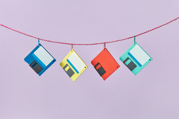 Four colored floppy disks hanging on rope