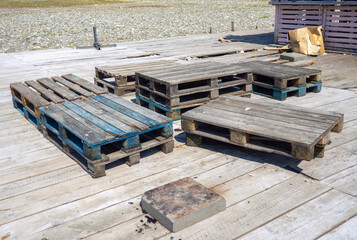 Darkened old pallets. Abandoned building materials. Construction garbage.
