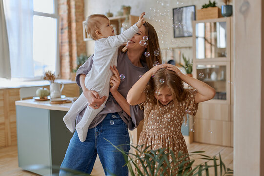 Mom And Kids Play With Soap Bubbles