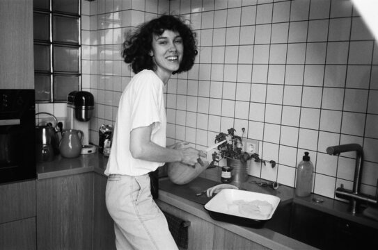 A smiling woman cutting a melon