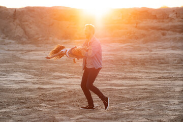 Father playing with daughter in desert