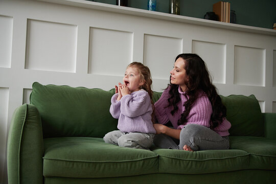 Sweet little girl is hugging and kissing her beautiful mom