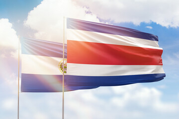 Sunny blue sky and flags of costa rica and el salvador
