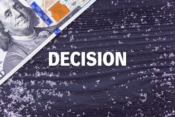DECISION - word (text) on a dark wooden background, money, dollars and snow. Business concept (copy space).