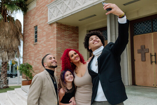 Fun family taking selfie on church steps
