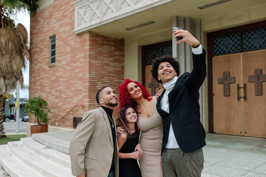 Happy family taking selfie on church steps