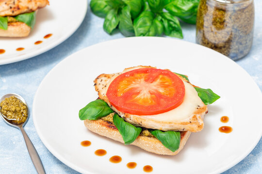 Open face sandwich with chicken, mozzarella, tomato, pesto and basil on toasted ciabatta, horizontal