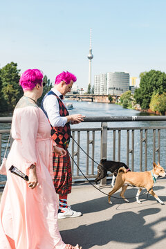 Alternative couple walking their dogs through East Berlin