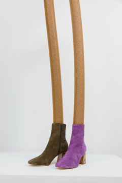 two different colored boots with propped legs