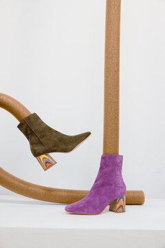two different colored boots with propped legs