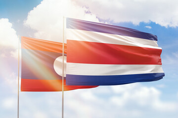 Sunny blue sky and flags of costa rica and laos