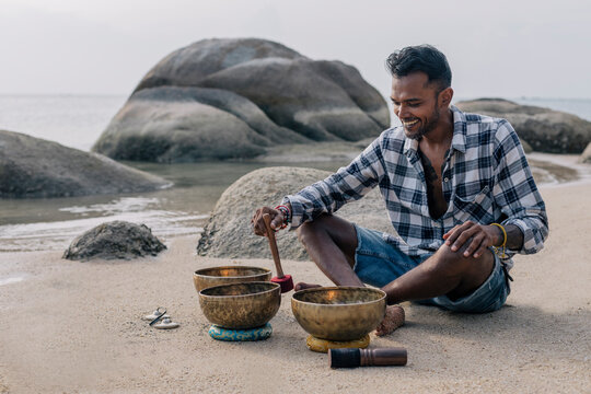 Male playing sound bowls.