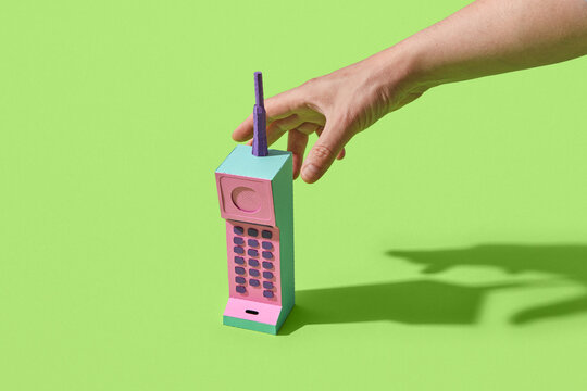 Colorful retro telephone made of paper in male hand
