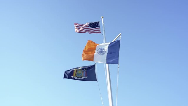 New York City Falg with USA Flag and New York State flying in strong wind on Hudson River in New York City Manhattan