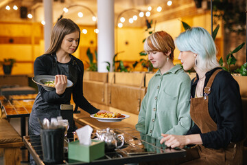 Clients receiving ordered dinner in cafe 