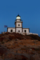 Fototapeta na wymiar The old lighthouse on the rocky cliff at night.