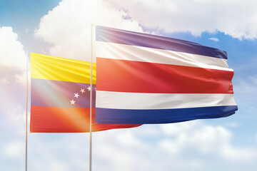 Sunny blue sky and flags of costa rica and venezuela