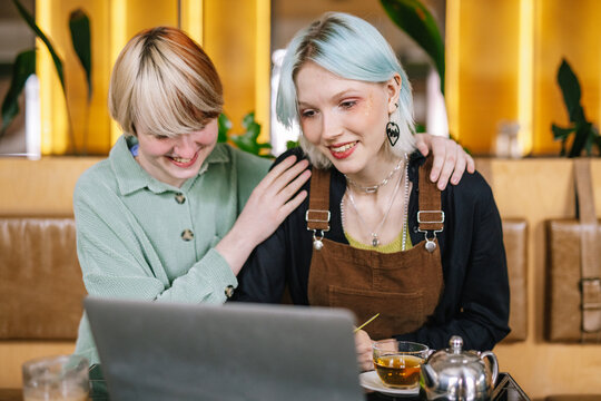 Female freelancer working with beloved person in cafe 