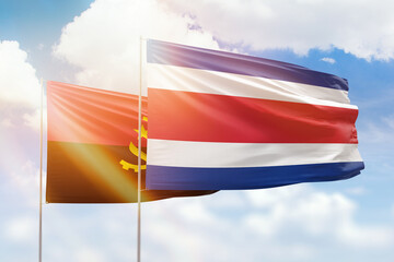 Sunny blue sky and flags of costa rica and angola