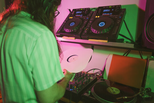 Dj holding Vinyl Records in his recording studio 