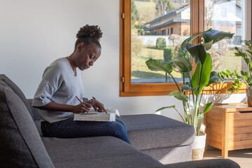 education, woman making a notes in big book at home