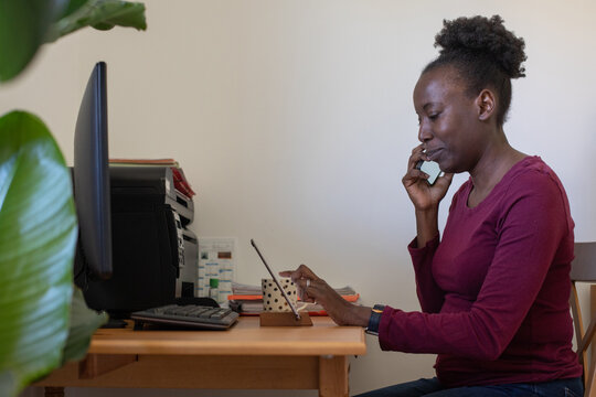 middle aged woman calling by phone at home workplace