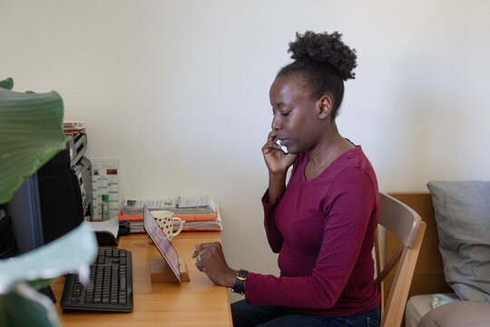 portrait of serious woman calling by phone at home workplace