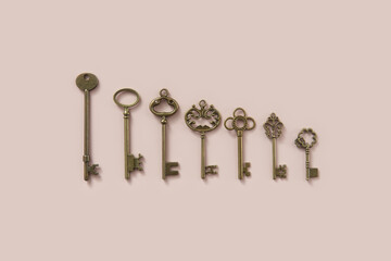 Vintage ornate keys of various size on beige background